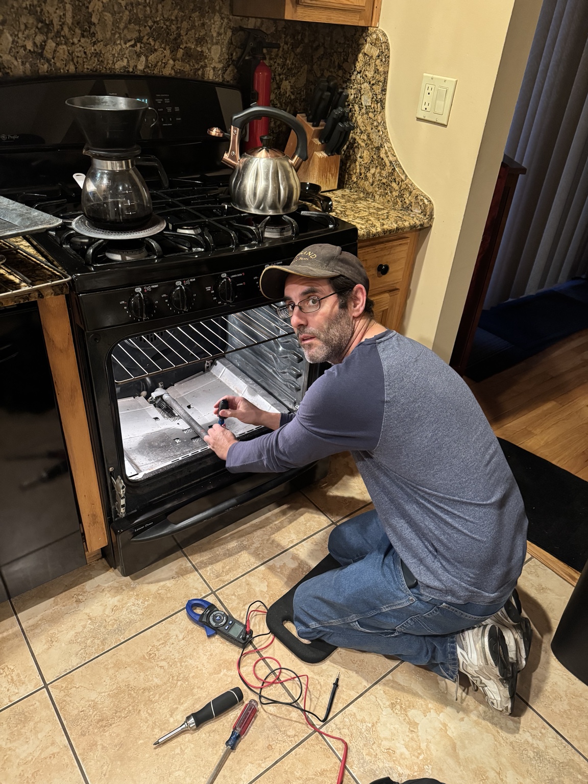 Adam repairing a range in a customer’s kitchen